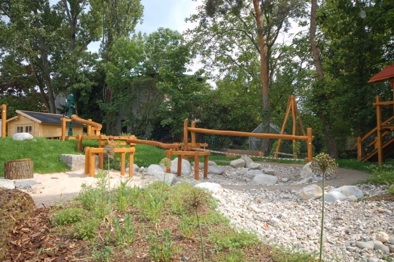 Kiesbett mit Holzbrücken und Sitzstämmen
