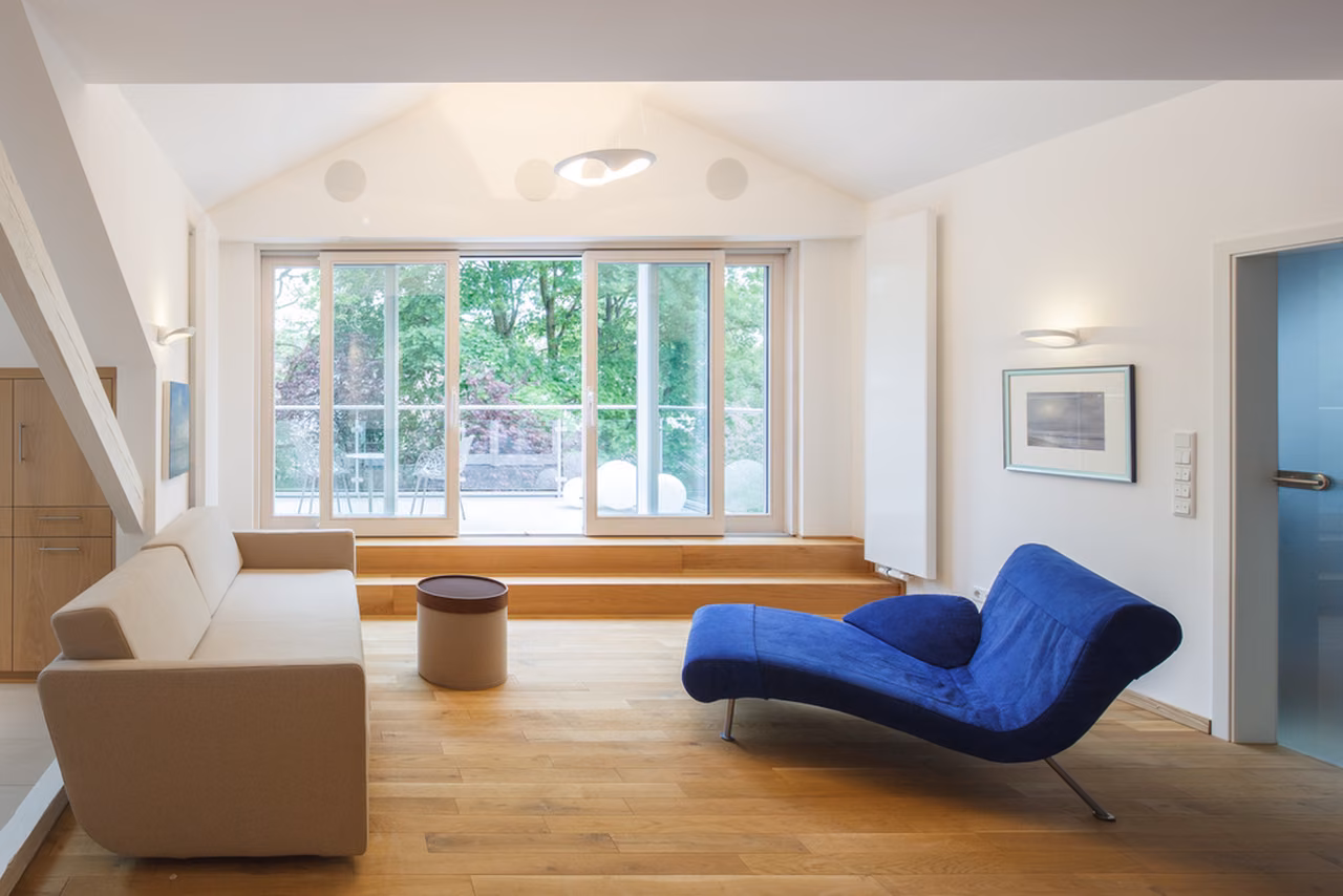 Wohnbereich mit Sofa und bodentiefem Fenster
