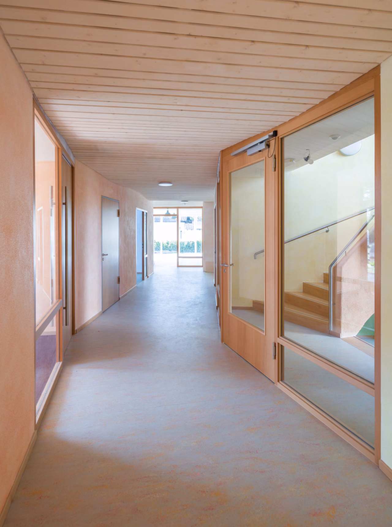 Flur mit Holzdecke und Glastür
