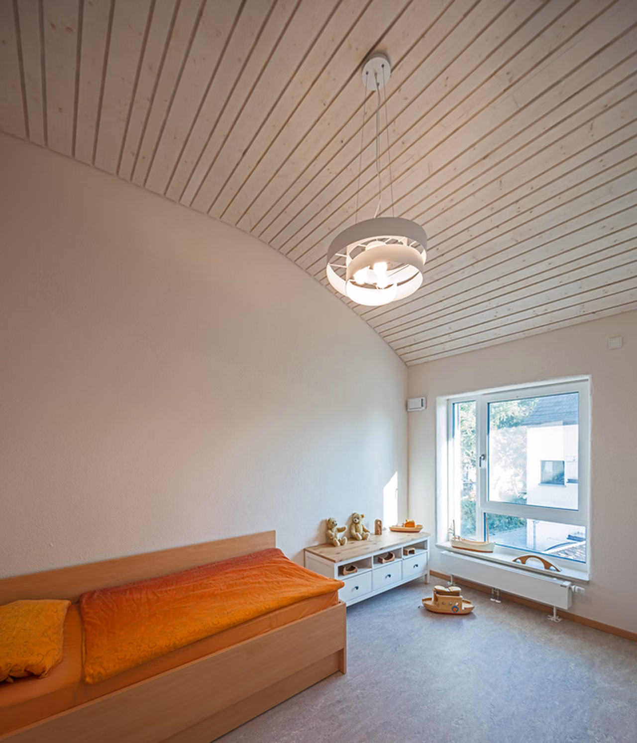 Zimmer mit gewölbter Holzdecke und Sitzbank am Fenster