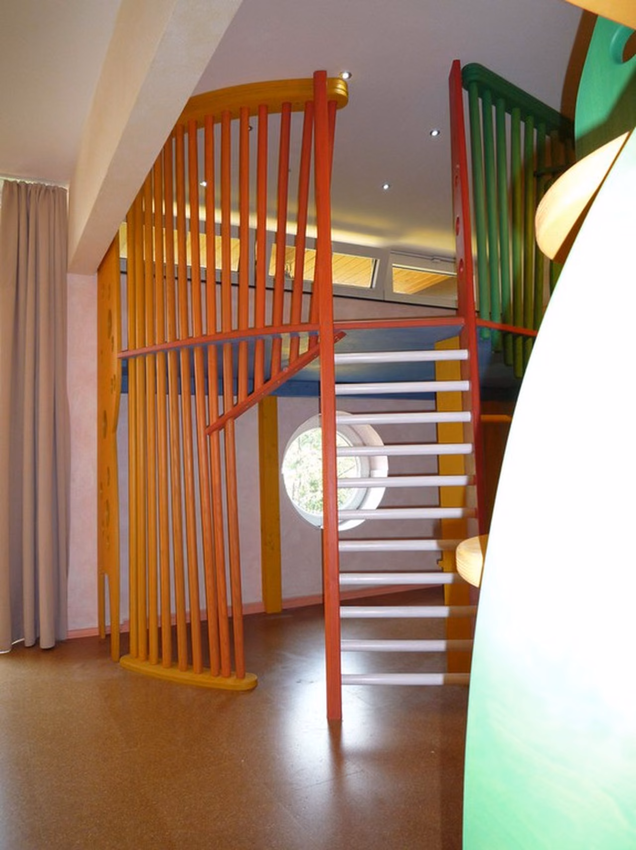 Spielbereich mit bunten Holzlatten und Leiter