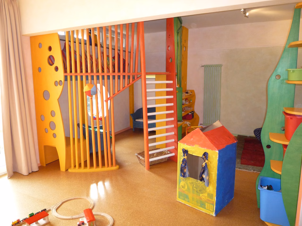 Spielhaus und Sprossenwand in kräftigen Farben