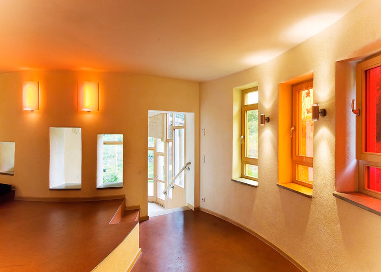 Flur mit Wandleuchten und roten Fensterrahmen