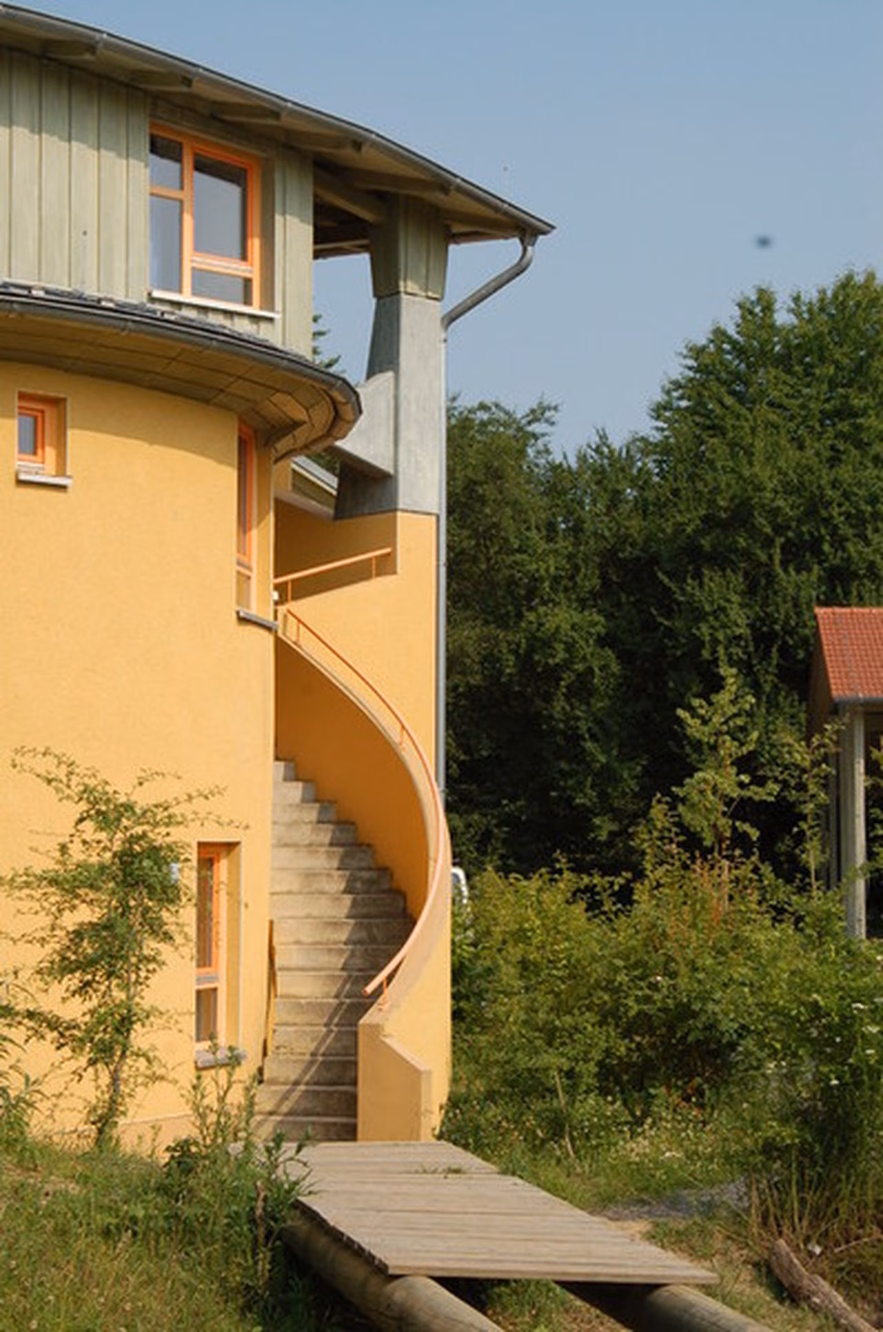 Naturnahe Fläche mit Holzsteg vor dem Wohnhaus