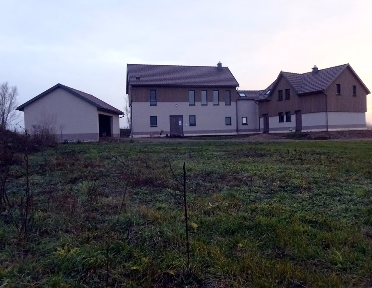 Wohnhaus mit Nebengebäuden am Feldrand